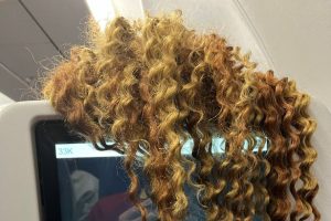 Man’s awkward plane dilemma as woman dangles hair over TV screen on 7-hour flight