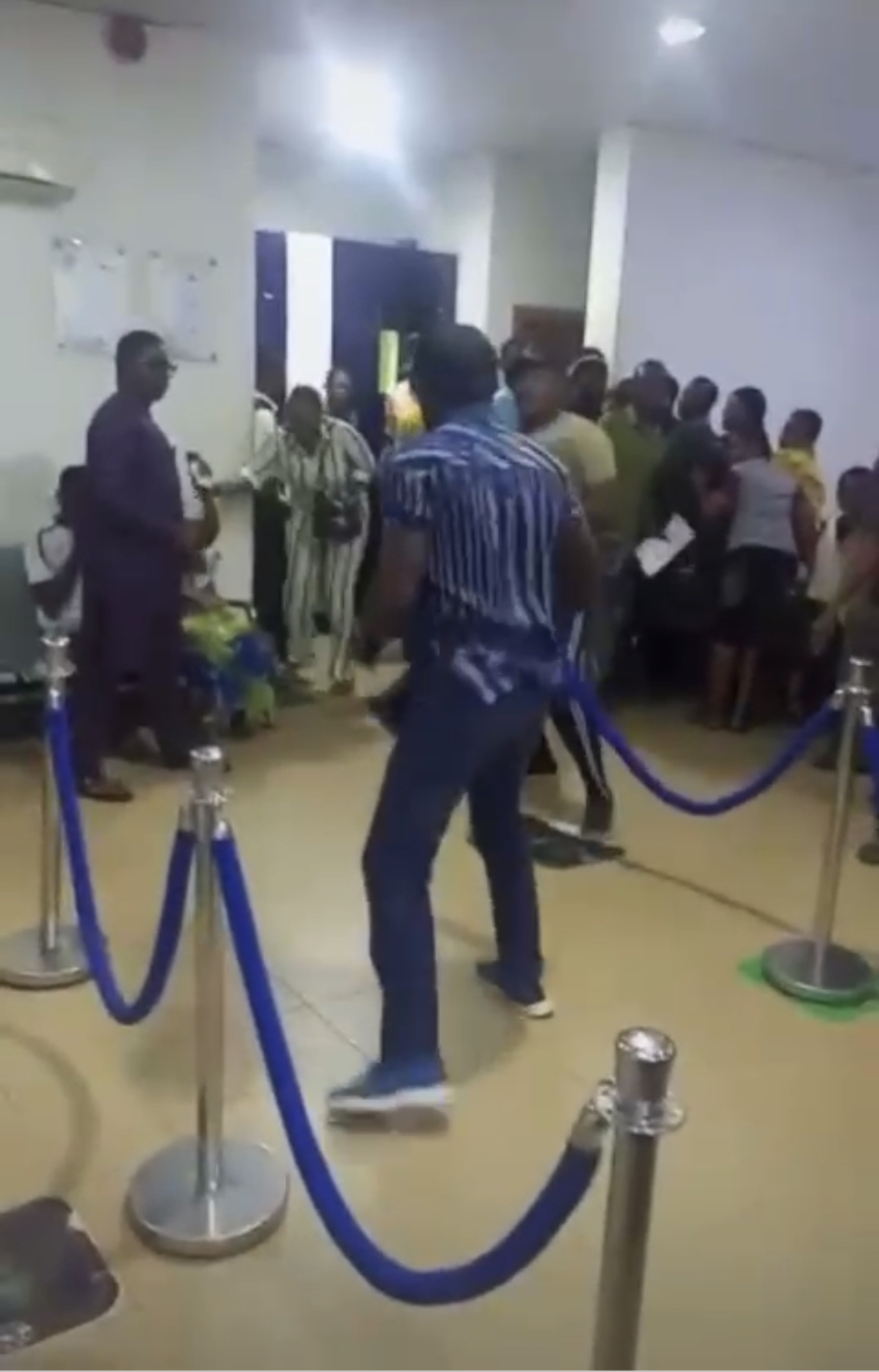 VIDEO: Watch as Nigerians throw weapons at each inside bank as new naira drought continues