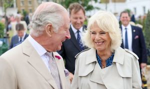 Queen Camilla rewears staple blue patterned dress with £630 trench coat for Dorset visit