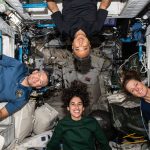 Expedition 70 astronauts pose for a portrait inside their crew quarters