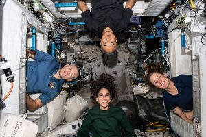 Expedition 70 astronauts pose for a portrait inside their crew quarters