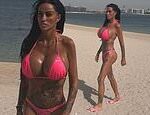Katie Price flaunts her assets in a hot pink bikini on the beach in Dubai just one day after British Airways cancelled flights there amid Middle East strikes