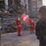 Father and son dress as Santa, visit Gaza tent city with gifts, music to celebrate New Year