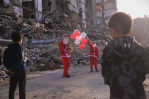 Father and son dress as Santa, visit Gaza tent city with gifts, music to celebrate New Year