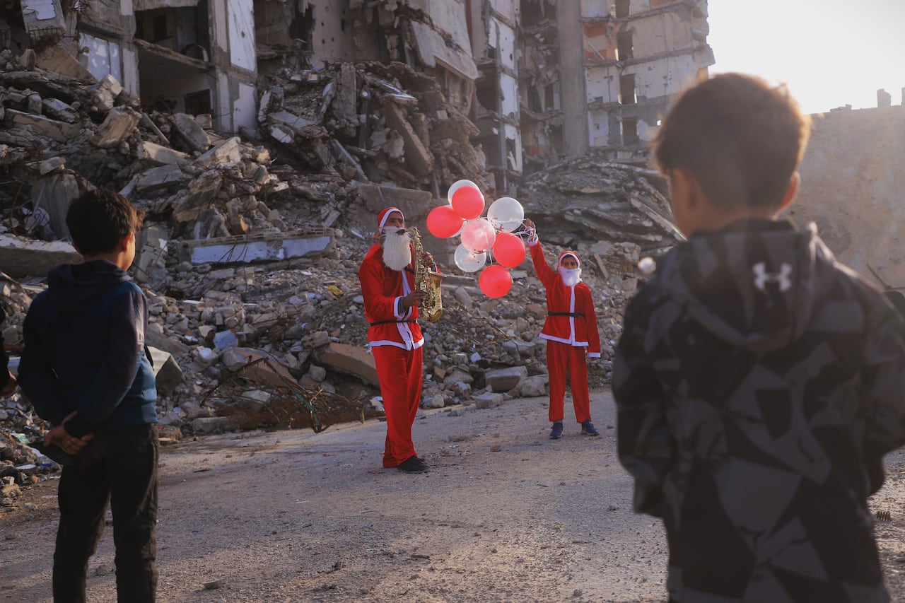Father and son dress as Santa, visit Gaza tent city with gifts, music to celebrate New Year